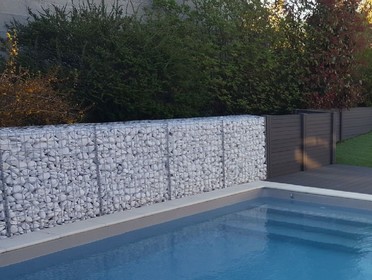 Gabion de galets blancs utilisé comme muret de piscine